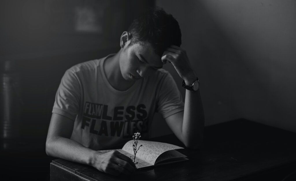 chico asiático leyendo un libro en blanco y negro